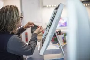 femme réparant l'écran d'un ordinateur